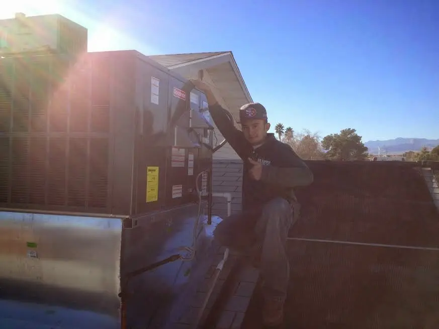 HVAC technician performing HVAC Inspection on a rooftop unit in Clarence